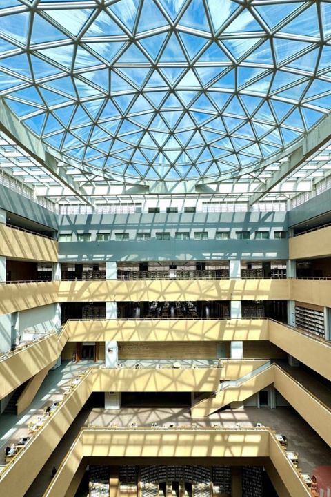 成都大學圖書館內部是「回」字形中庭設計，挑高的空間搭配通透落地窗，自然光從頭頂傾瀉而下，把大廳照得明亮又溫柔。圖/取自《川觀新聞》