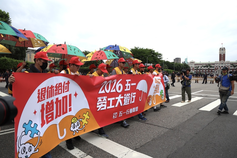 「五一行動聯盟」1日舉行勞工大遊行，現場參與者高呼「退休給付增加、本勞移工全保」等口號。圖/中央社