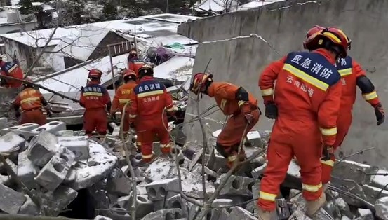 救援人員在倒塌的磚瓦堆上前行，全力搜救中。圖／新華社