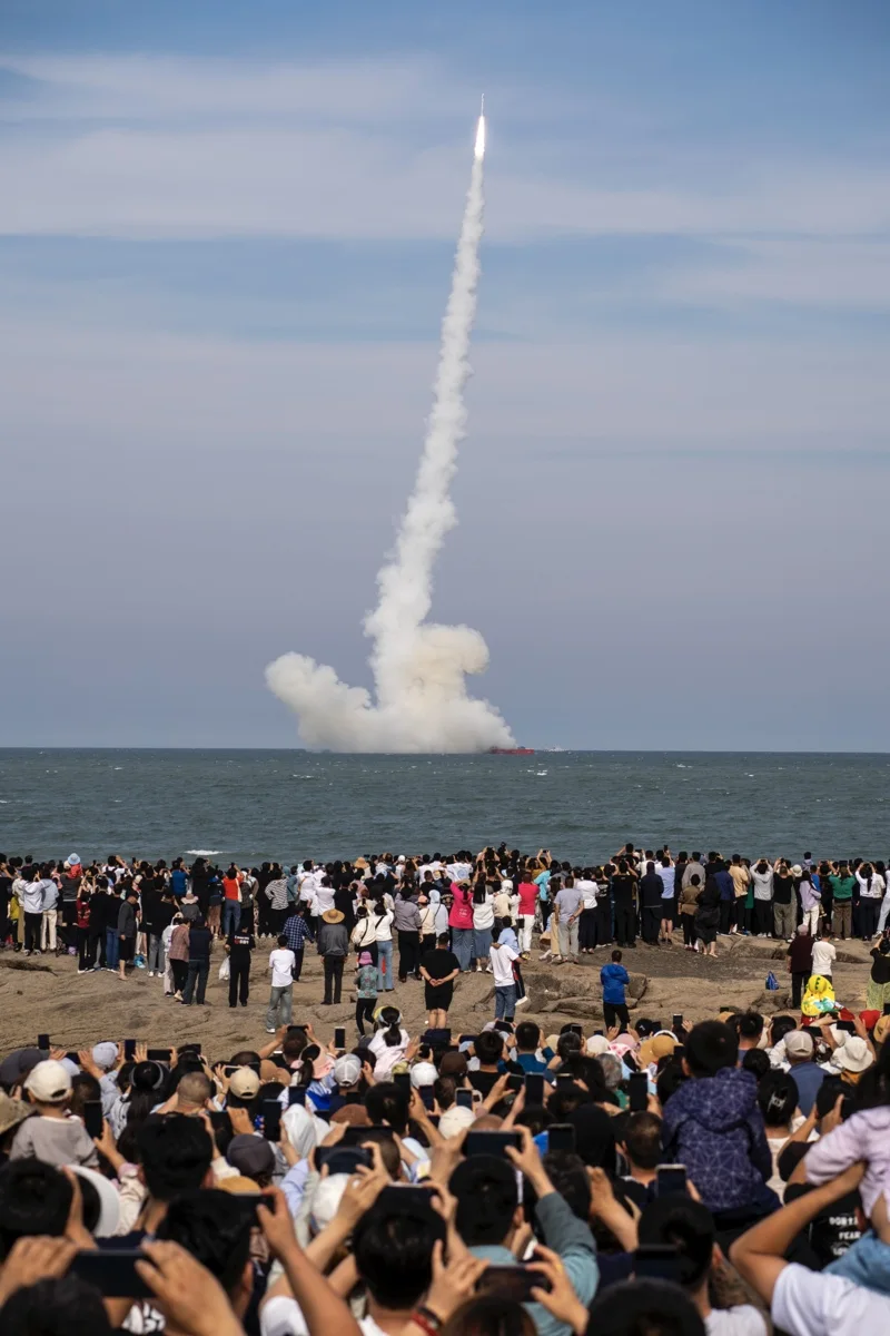 發射穀神星一號海射型遙三運載火箭，民眾好奇拍攝。圖/取自新華社