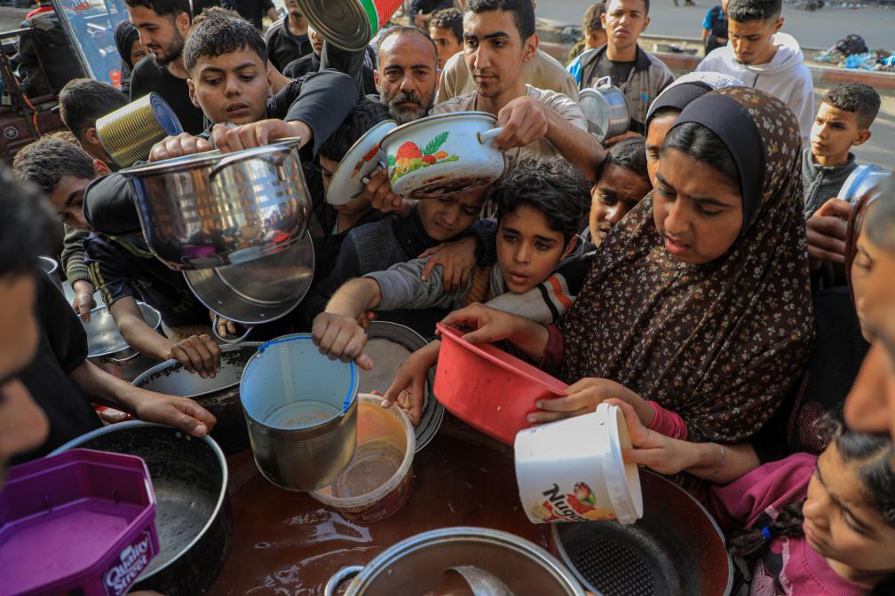 圖為巴勒斯坦人4月在加薩南部城市拉法等待領取食物。圖/取自新華社
