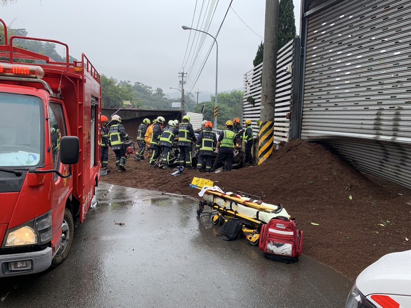 砂石車翻覆，大量沙土傾倒在道路上，然而砂石車司機否認超載導致事故。圖/中央社