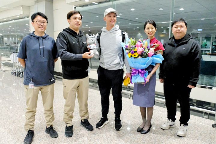   目前效力美國職棒大聯盟克里夫蘭守護者隊的台美混血好手費爾柴德（中）26日晚間搭機抵台，將投入經典賽台灣隊，中職也派員赴機場迎接。圖/中央社