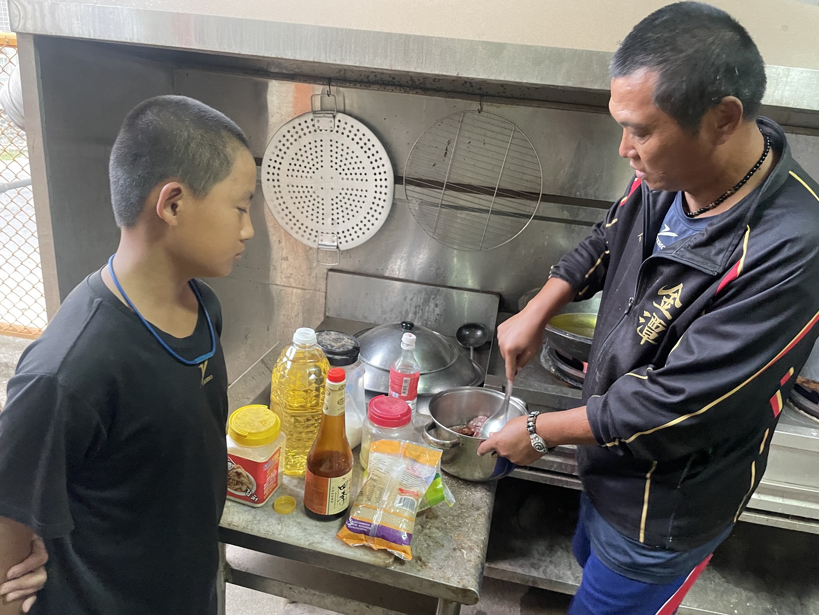 金潭國小棒球隊總教練徐宏根化身大廚，為小球員們準備晚餐。圖/頂新和德提供