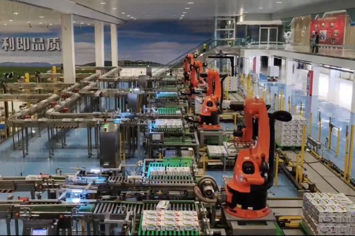 機械臂以真空吸附的方式吸起奶箱，一條機械手臂能負責的工作量，相當於60名人工。圖/記者陳素貞攝
