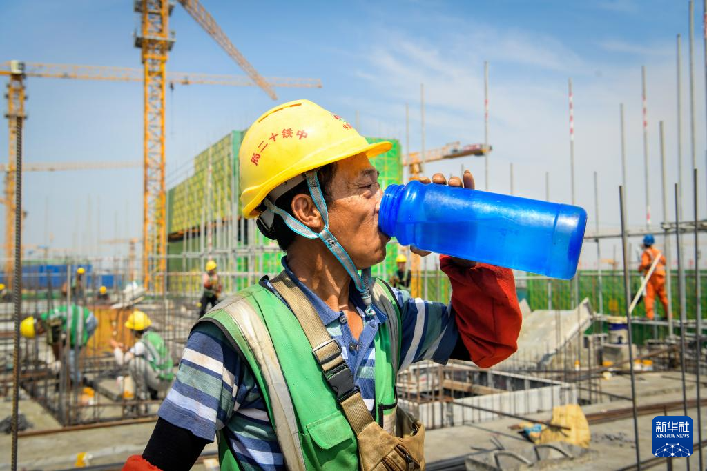 勤奮的工作者在高溫下奮戰，工人在河北雄安新區建設現場喝水解暑。圖/取自新華社