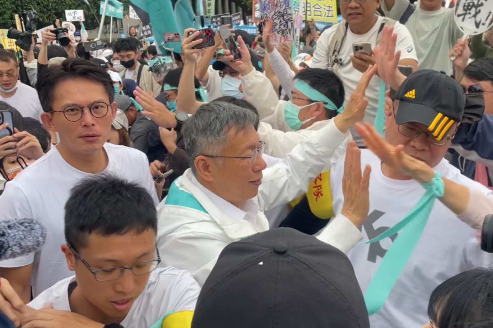 民眾黨創黨主席柯文哲(中)在民眾黨主席黃國昌(左)的陪同下離開凱道現場。圖/記者洪子苓攝