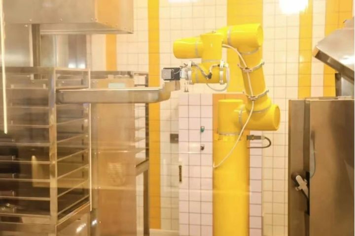 上海虹橋社區AI食堂，機械臂正在自動化烹飪作業。圖/取自澎湃新聞