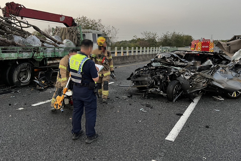 撞上故障大貨車的小客車瞬間成了一團廢鐵，駕駛被救出後已明顯死亡。圖/中央社