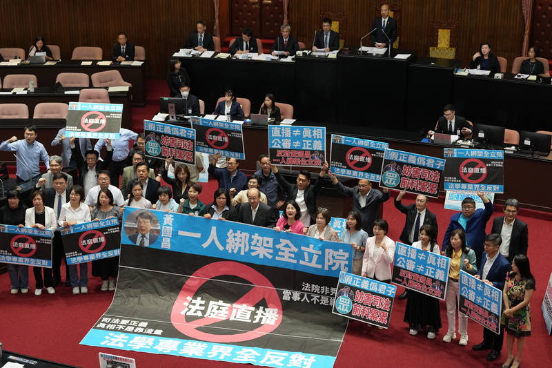 民進黨立法院黨團批評不應把法庭當直播秀場,遂行特定個案全民公審的政治意圖,圖為綠委在立法院議場貼海報表達訴求。圖/中央社