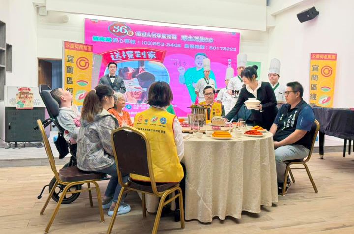 羅東高商準備熱騰騰年菜，由游政恩同學(圖右)進行上菜秀，讓現場貴賓品嘗美味佳餚，感受年節團圓氛圍。圖/永慶房產集團提供)