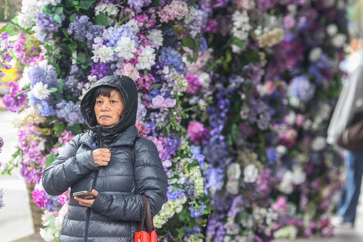 天氣濕涼，台北市信義區街頭有民眾穿上羽絨外套禦寒。圖/取自中央社