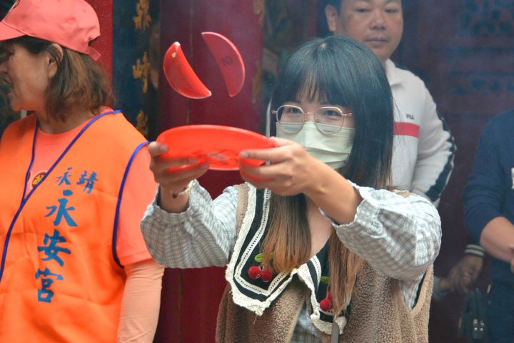 民眾於永安宮參與「擲筊挑戰賽」，親手擲筊向神明祈福，感受永靖歲末謝平安的傳統信仰儀式，現場氣氛熱絡。圖/頂新和德文教基金會提供