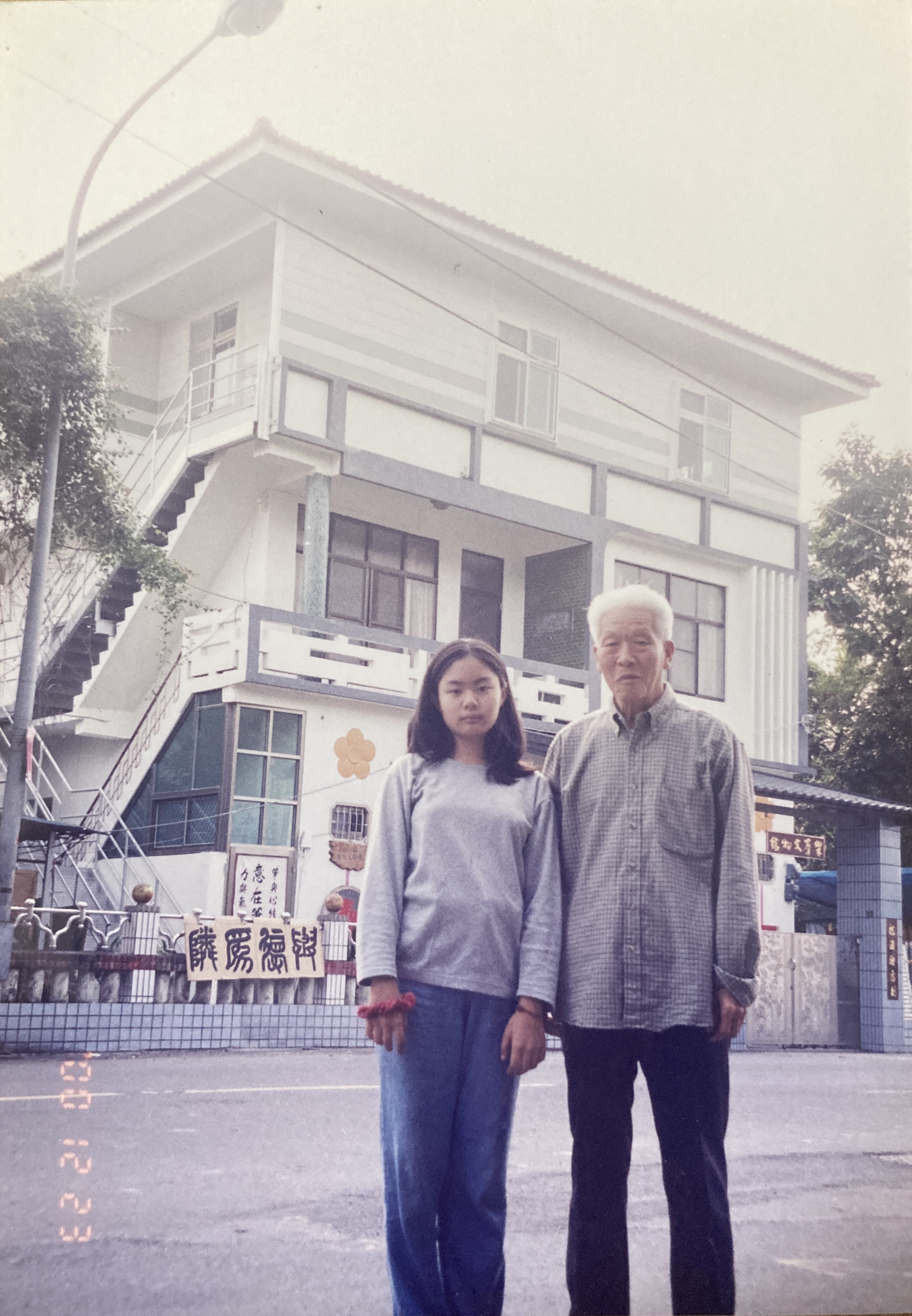 張紹熙與孫女2000年攝於樂群館前。圖/張仲嫣提供