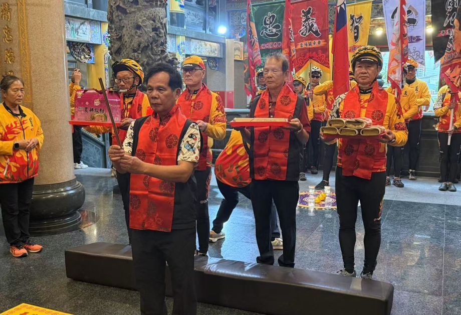 騎行隊抵達沙鹿義聖宮吳卯水主委(中)擔任祈福官,游同人理事長(後排左二)祈望全台風調雨順國泰民安。圖/張蔭泉攝